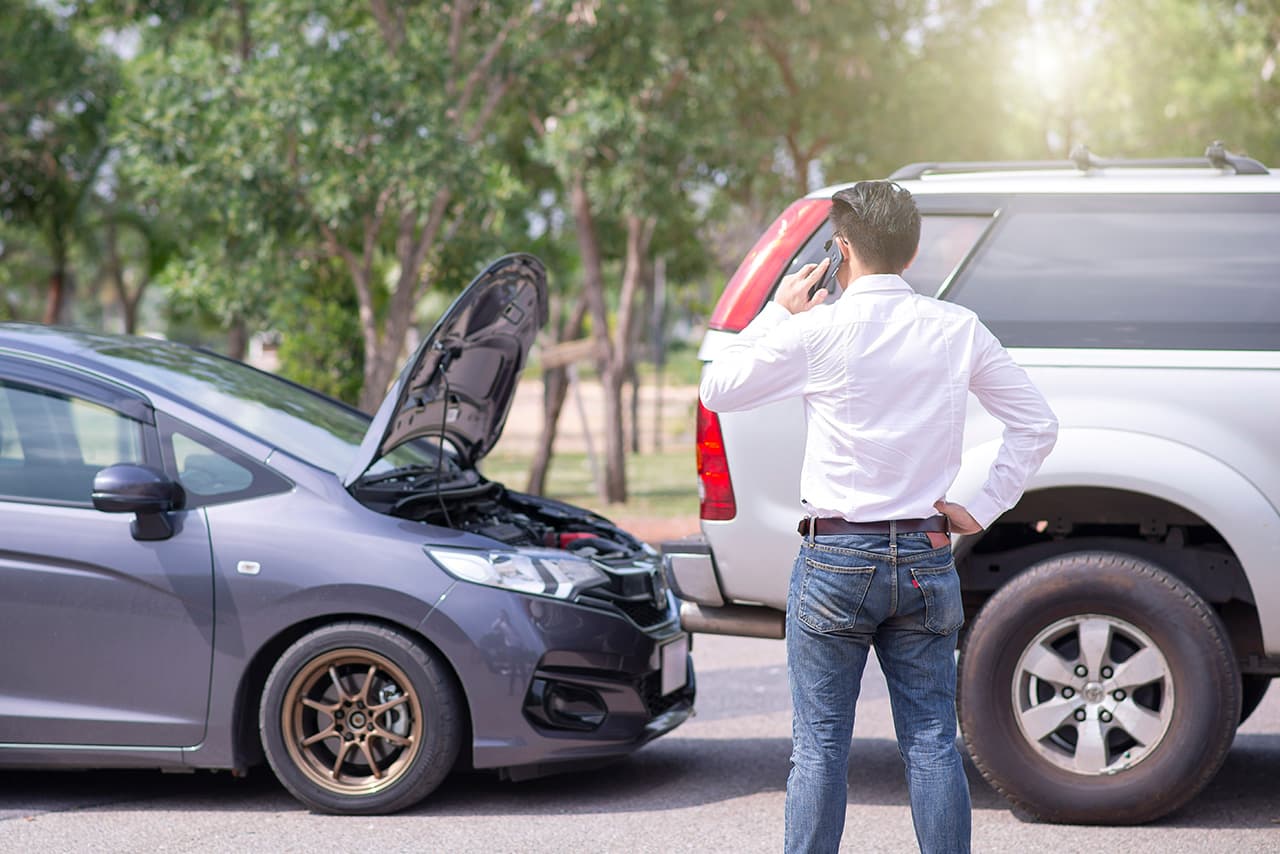 車をぶつけて、電話をかけている男性